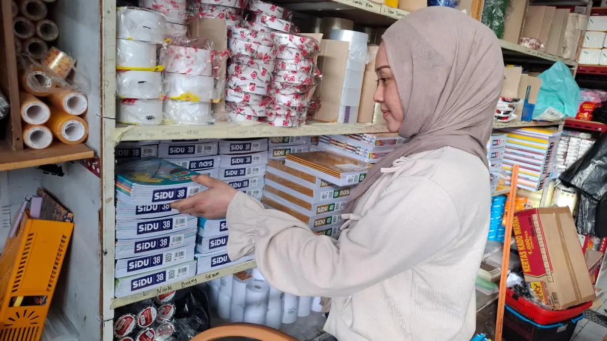 PANEN OMZET: Karyawan merapikan tumpukan buku tulis di salah satu toko alat tulis kantor (ATK) kawasan Kelurahan Sisir, beberapa hari lalu.