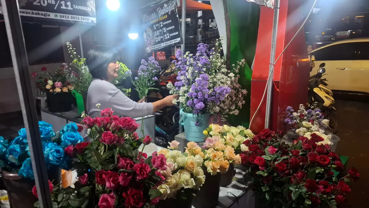 DIMINATI PASANGAN MUDA: Pemilik salah satu toko bunga di kawasan Alun-Alun Kota Batu merapikan produk dagangannya beberapa hari lalu.
