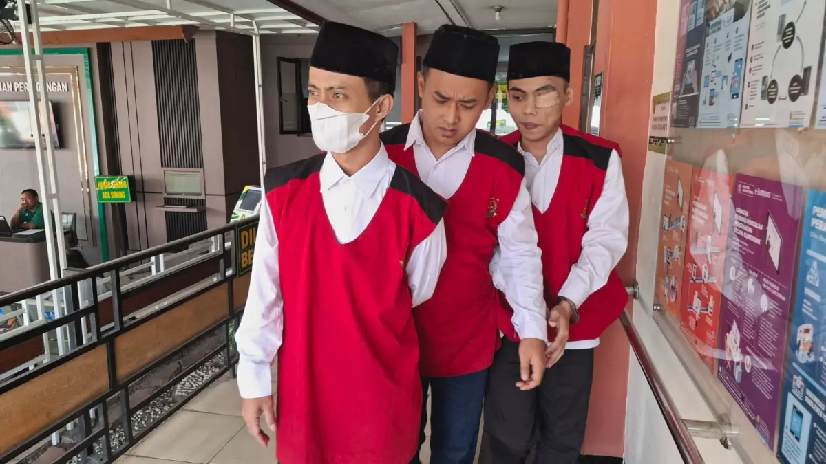 PENCURIAN EMAS: Terdakwa pencurian 220 keping emas Qasan (kiri) dan Rio(tengah) berjalan keluar dari ruang sidang cakra Pengadilan Negeri Kota Malang kemarin (8/7).