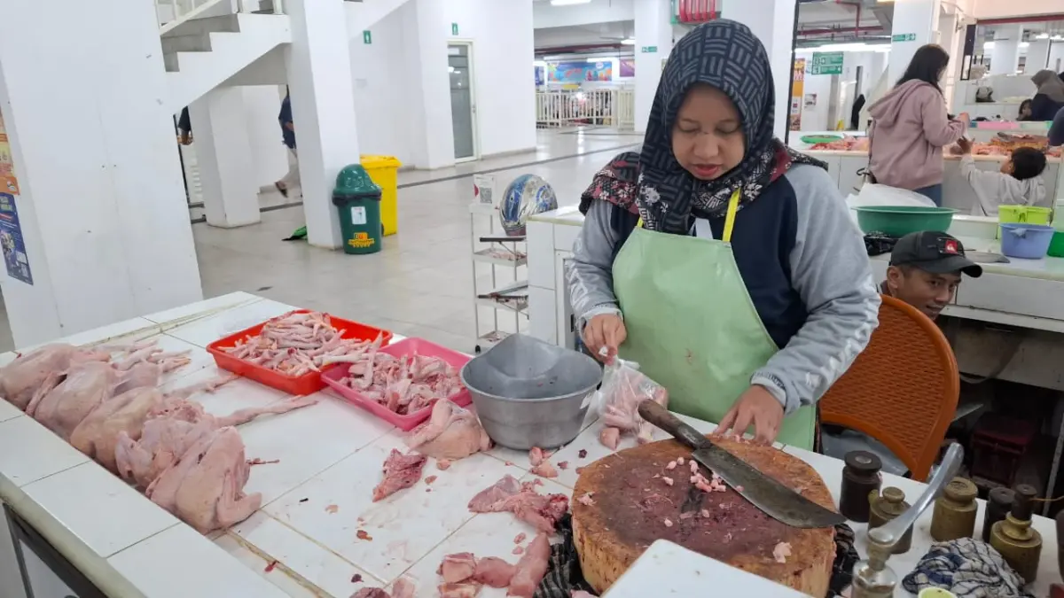 Pedagang Pasar Induk Among Tani Batu mengemas daging ayam potong. (RAMIZARD RAFSANJANI/RADAR BATU)