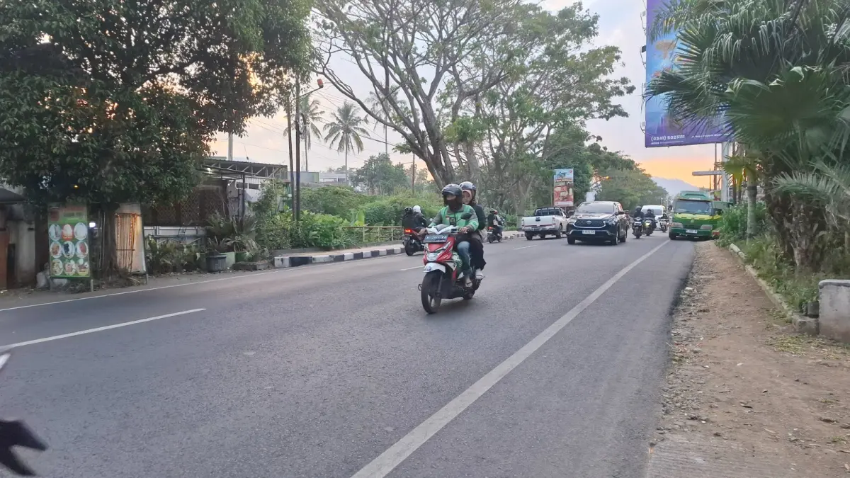 TARIF NAIK: Driver ojol tampak mengantar pengguna jasa melintasi Jalan raya Pattimura, Kelurahan Temas, Kecamatan Batu pada Jumat lalu (3/7).