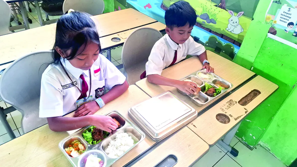 PERDANA MASUK SEKOLAH: Beberapa siswa SDN 02 Junrejo Kota Batu tampak menikmati hidangan MBG yang disalurkan pada hari pertama masuk sekolah kemarin (13/7).