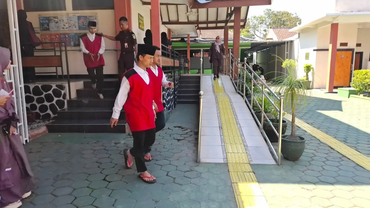 PENCURIAN EMAS:  Rio dan Qasan berjalan keluar dari Ruang Sidang Cakra Pengadilan Negeri Malang setelah sidang pembacaan pledoi kemarin (15/7).