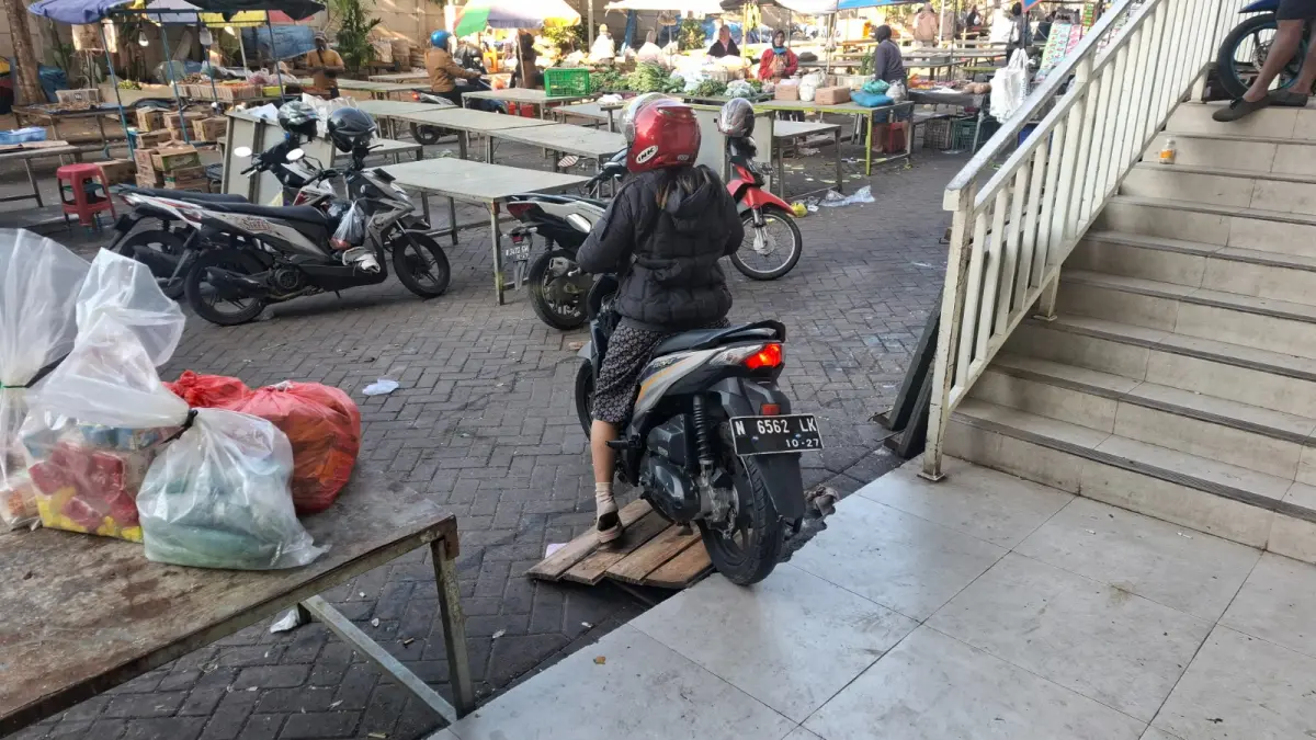 MELANGGAR ATURAN: Salah satu kendaraan roda dua tampak keluar dari selasar Pasar Induk Among Tani Kota Batu beberapa waktu lalu. Praktik tersebut memicu kerusakan keramik dan kendala kebersihan.