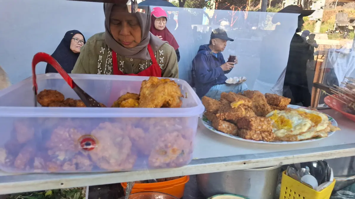 UMKM LOKAL: Pedagang UMKM CFD Mbatu Sae menyiapkan nasi empok pesanan pelanggan kemarin (19/7). (RAMIZARD RAFSANJANI/RADAR BATU)
