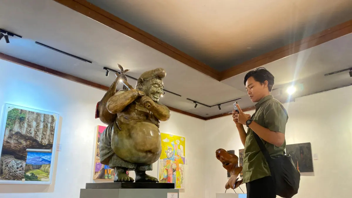 PENUH MAKNA: Salah satu pengunjung tampak mengabadikan karya instalasi yang paling ikonik Semar dalam pameran bertajuk Like a Rolling Stone di Galeri Raos kemarin (21/7). (RORI DINANDA BESTARI/RADAR BATU)