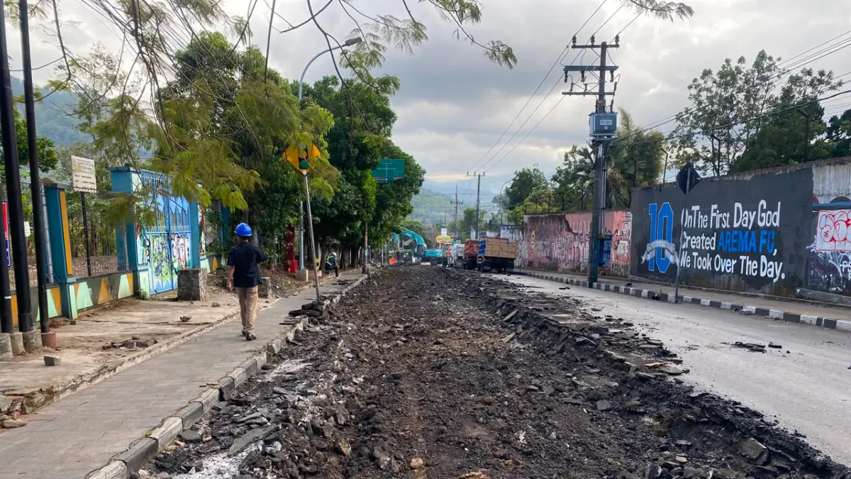 MULAI DIKERJAKAN: Alat berat membongkar aspal lama sepanjang 120 meter di Jalan Hasanudin untuk diganti beton kemarin (23/7). (RORI DINANDA BESTARI/RADAR BATU)