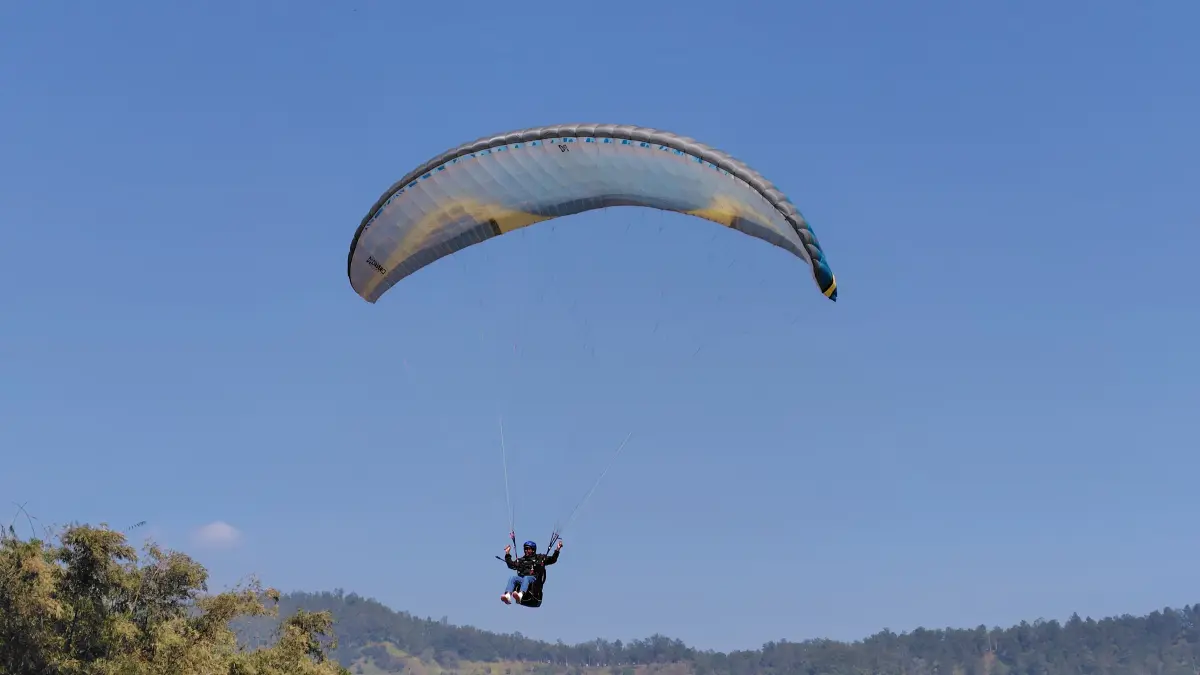 MEMUKAU PENONTON: Beberapa atlet paralayang bersiap landing di Lapangan Songgomaruto, Kelurahan Songgokerto, Kecamatan Batu kemarin pagi (31/7). (RORI DINANDA BESTARI/RADAR BATU)