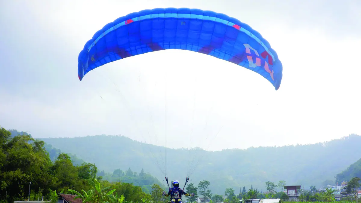 DITATA ULANG: Sejumlah tandem paralayang bersiap take off di Lapangan Songgomaruto pada Minggu lalu (2/8). (RORI DINANDA BESTARI/RADAR BATU)