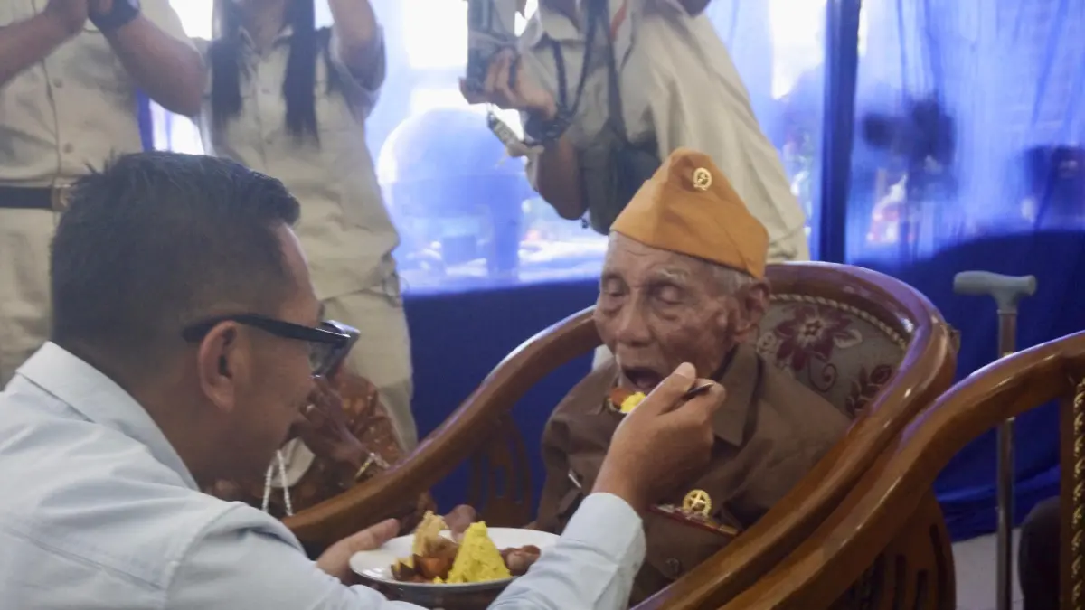 BERI PERHATIAN: Wali Kota Batu Nurochman menyuapkan nasi kuning kepada anggota veteran di Kantor LVRI Kota Batu kemarin (11/8). (RORI DINANDA BESTARI/RADAR BATU)