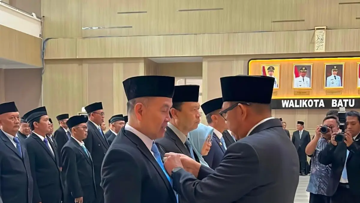 TERIMA PENGHARGAAN: Wali Kota Batu Nurochman menyematkan tanda kehormatan Satyalancana Karya Satya kepada salah seorang ASN kemarin (13/8). (RORI DINANDA BESTARI/RADAR BATU)