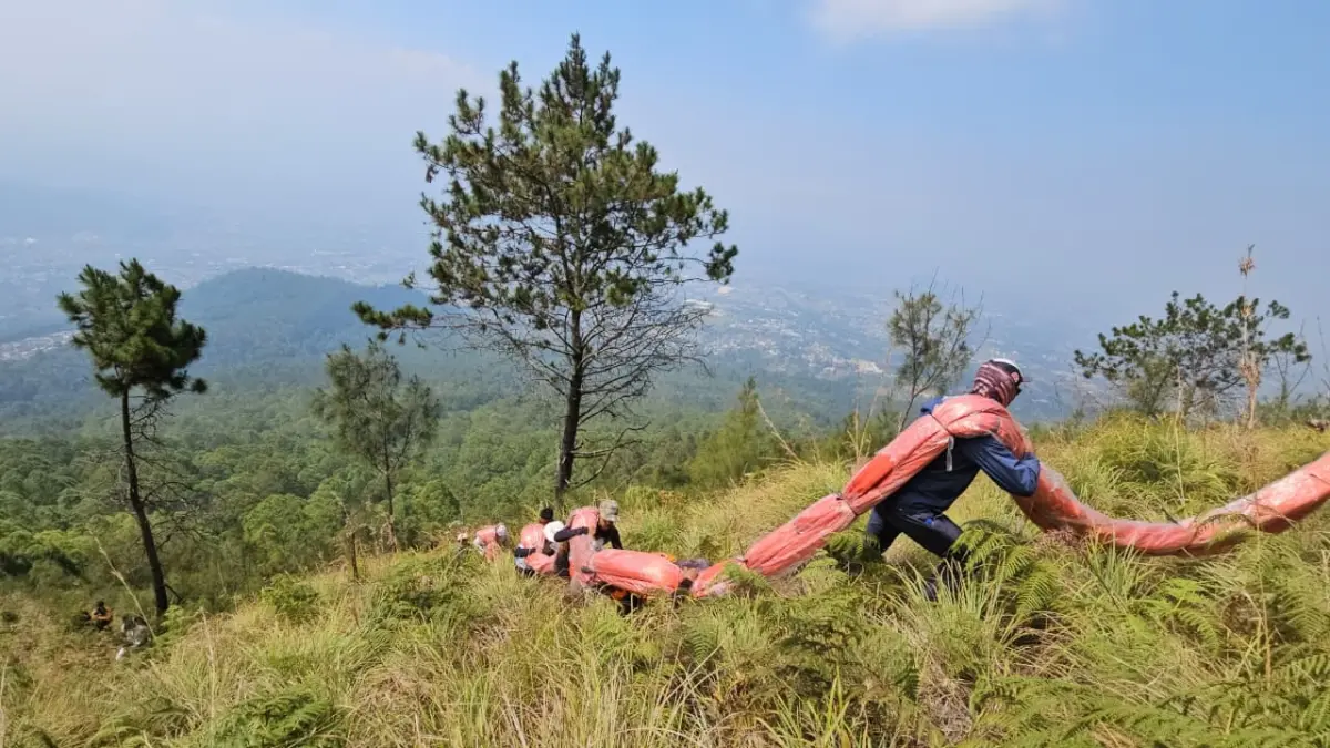 HUT KE-81 RI: Sejumlah anggota pencinta alam berbondong-bondong membawa bendera untuk dibentangkan di lereng Gunung Panderman kemarin (17/8). (RORI DINANDA BESTARI/RADAR BATU)