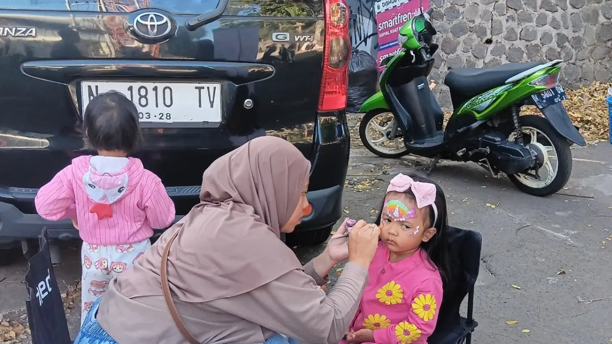 MENJANJIKAN: Seniman melukis wajah anak-anak di Car Free Day (CFD) Mbatu Sae kemarin (23/8). (INDAH MEI YUNITA/RADAR BATU)