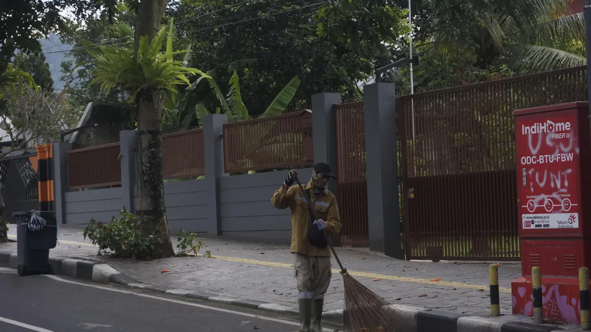 NAIK STATUS: Salah seorang penyapu jalanan bertugas di kawasan Jalan Panglima Sudirman kemarin (24/8). (RORI DINANDA BESTARI/RADAR BATU)
