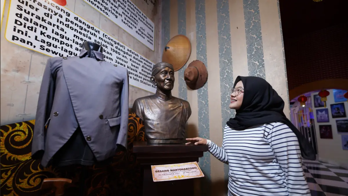 MENGENANG SANG MAESTRO: Salah satu pengunjung mengamati koleksi busana sang maestro keroncong Indonesia sekaligus pencipta lagu Bengawan Solo, Gesang, di Museum Musik Dunia Jatim Park 3. (JAWA TIMUR PARK GROUP FOR RADAR BATU)