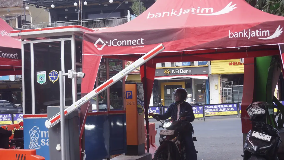 DALAM KAJIAN: Salah seorang wisatawan mengakses gate parkir di Alun-Alun Kota Batu beberapa hari lalu. (RORI DINANDA BESTARI/RADAR BATU)