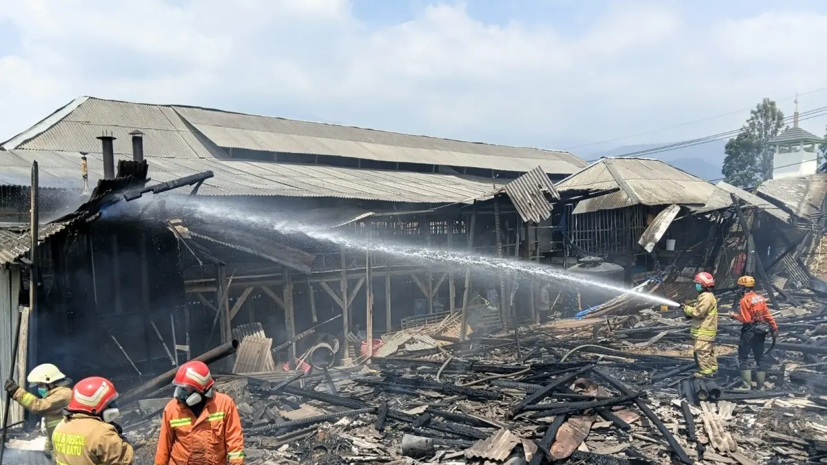 KEBAKARAN: Petugas pemadam kebakaran membersihkan puing-puing kebakaran kandang ayam di Jalan Metro, Kelurahan Sisir, Kecamatan Batu kemarin (31/8).(KELURAHAN SISIR FOR RADAR BATU)