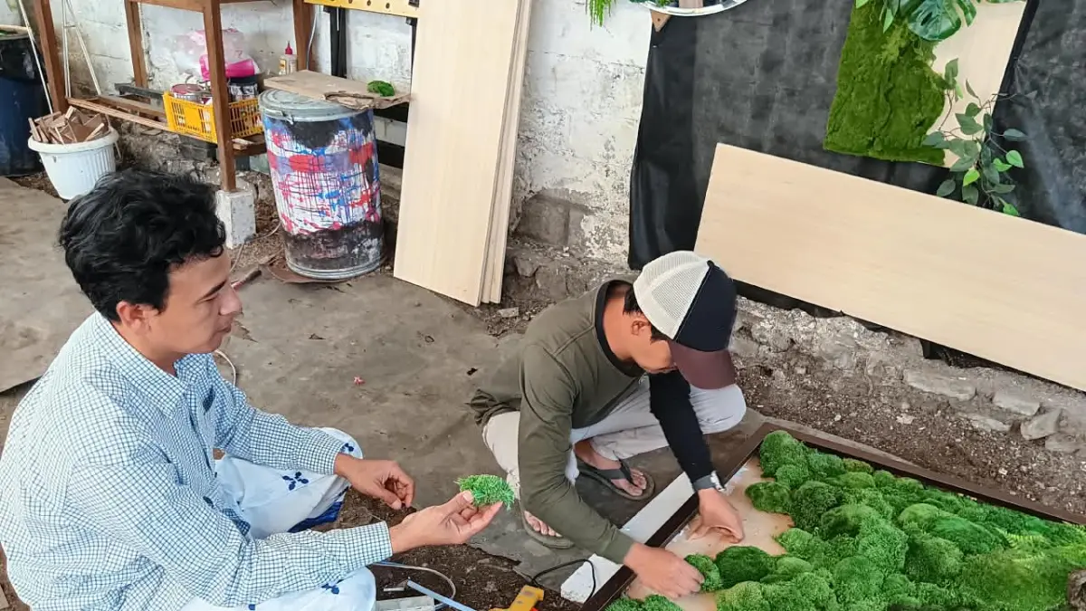 KREATIF: Seniman moss art menyusun moss di atas bingkai di Lucky Garden, Desa Sidomulyo, Kecamatan Batu beberapa hari lalu. (INDAH MEI YUNITA/RADAR BATU)