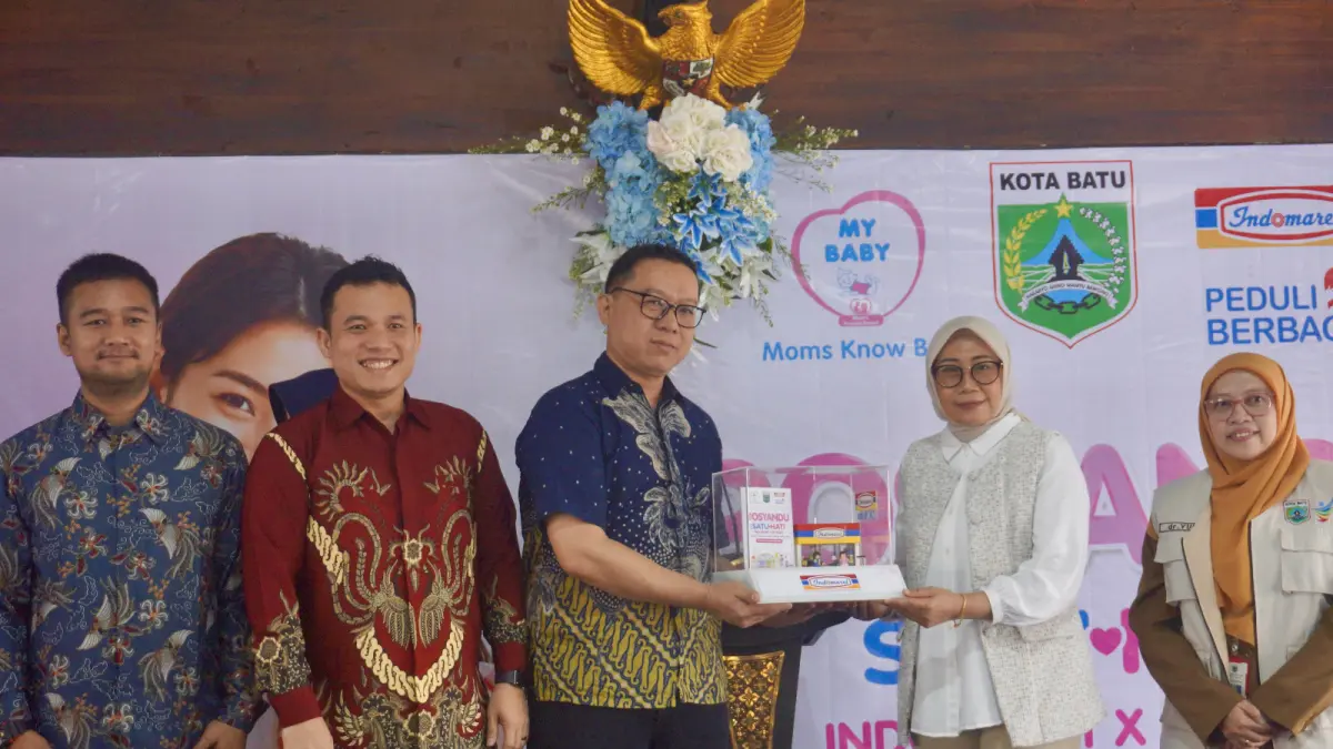 JALIN KERJA SAMA: Deputy Branch Manager PT Indomarco Prismatama Cabang Malang Fhiter Tandoko menyerahkan cenderamata kepada Ketua TP PKK Kota Batu Siti Faujiyah Nurochman dalam kegiatan Gebyar Posyandu di Pendapa Rumdin Wali Kota Batu kemarin (8/9). (RORI DINANDA BESTARI/RADAR BATU)