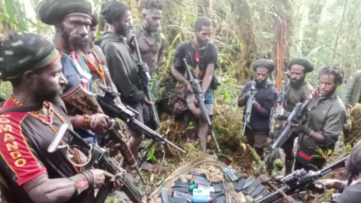 Personel Tentara Pembebasan Nasional Papua Barat-Organisasi Papua Merdeka (TPNPB-OPM) bersenjata di samping barang-barang yang diklaim hasil rampasan dari TNI-Polri. Foto: Ist