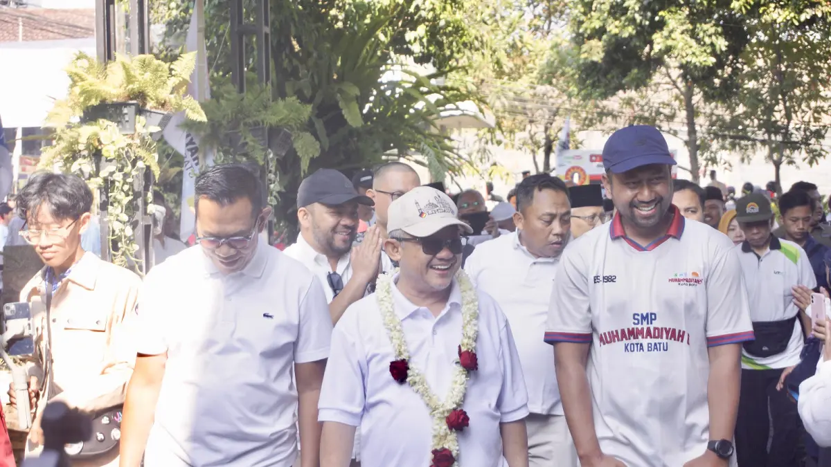 KUNJUNGAN RESMI: Mendikdasmen RI Abdul Mu’ti (tengah), didampingi Wali Kota Batu Nurochman (kiri) dan Kepala SMP Muhammadiyah 8 Batu Windra Rizkyana (kanan) menuju tempat peresmian gedung di kawasan Perguruan Muhammadiyah kemarin (20/9). (RORI DINANDA BESTARI/RADAR BATU)