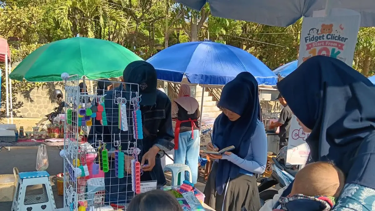 TREN BARU: Anak-anak di Car Free Day (CFD) Mbatu Sae membeli fidget clicker di salah satu lapak kemarin (27/9). (INDAH MEI YUNITA/RADAR BATU)