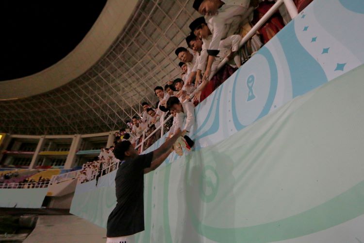 BERBAGI SENYUM: Pemain Timnas Jerman Winner Osawe memberikan sepatu yang digunakannya saat final Piala Dunia U-17 ke seorang santri asal Solo yang menonton laga ini di Stadion Manahan (2/12).