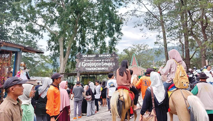 MANFAATKAN LIBURAN: Wisatawan antre masuk ke kawasan objek wisata Grojogan Sewu di Tawangmangu, kemarin (25/12).
