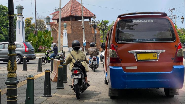 JAGA JARAK: Pengendara sepeda motor berjalan tepat di samping kendaraan umum. (ISTIMEWA)