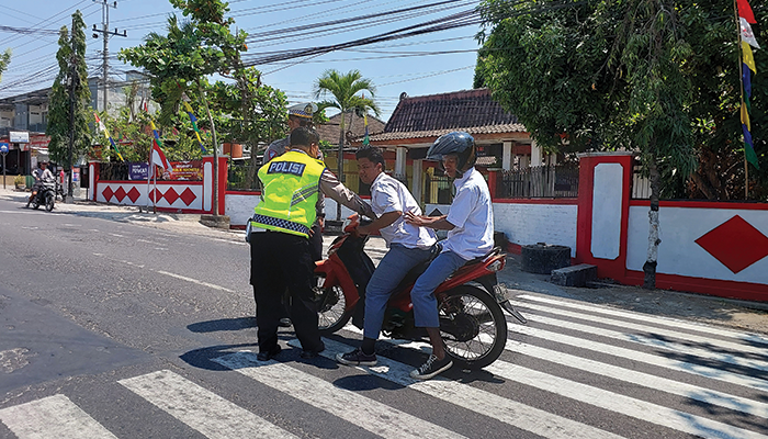 TERTANGKAP: Tilang siswa yang melanggar lalu lintas tidak mengenakan helm di Jalan Raya.