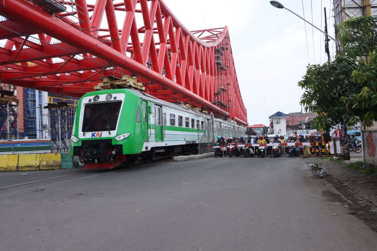 TERTIB: Pengendara motor menunggu kereta lewat saat berada di Jembatan Layang Joglo, kemarin. (M. IHSAN/RADAR SOLO)