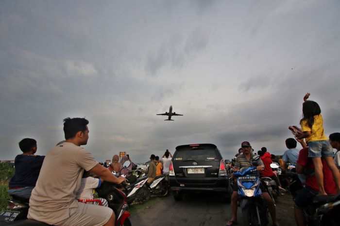 ANTUSIAS: Warga berkerumun melihat pesawat terbang lepas landas di jalan Desa Ngresep, Kecamatan Ngemplak, Kabupaten Boyolali. (ARIEF BUDIMAN/RADAR SOLO)