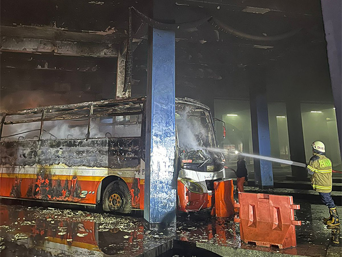 Personel Damkar Kota Solo lakukan pendinginan terhadap bodi Bus Rela yang terbakar di Terminal Tirtonadi, Minggu (11/2/2024) malam. (ISTIMEWA)