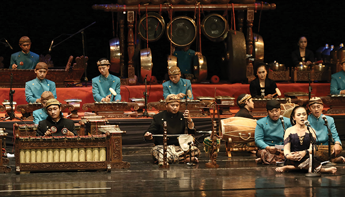 Para niyaga sedang memainkan seperangkat gamelan.
