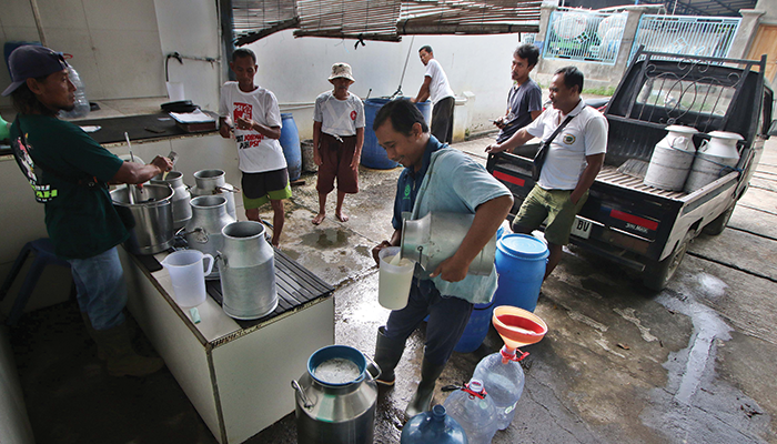 TERUS PULIH: Peternak sapi perah di Desa Singosari, Kecamatan Mojosongo, Kabupaten Boyolali menjual hasil susunya ke pengepul, beberapa waktu lalu. Produksi sapi di Boyolali sempat turun karena LSD da
