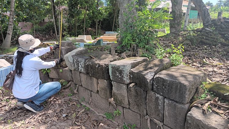 MASIH DITELITI: Pegiat cagar budaya memperlihatkan batuan candi yang ditemukan di salah satu kompleks makam Desa Kahuman, Kecamatan Ngawen. (ANGGA PURENDA/RADAR SOLO)