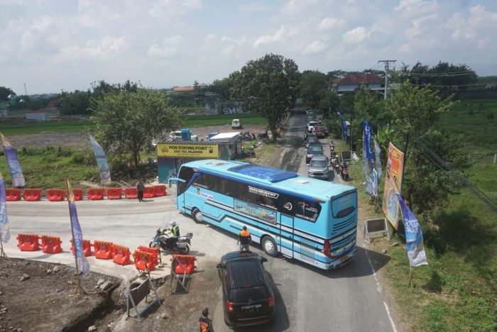 Bus pariwisata bertuliskan mudik gratis yang kedapatan melintasi tol fungsional Solo-Jogja di Desa Ngawen, Kecamatan Ngawen, Klaten, Minggu (14/4). (ANGGA PURENDA/ RADAR SOLO)