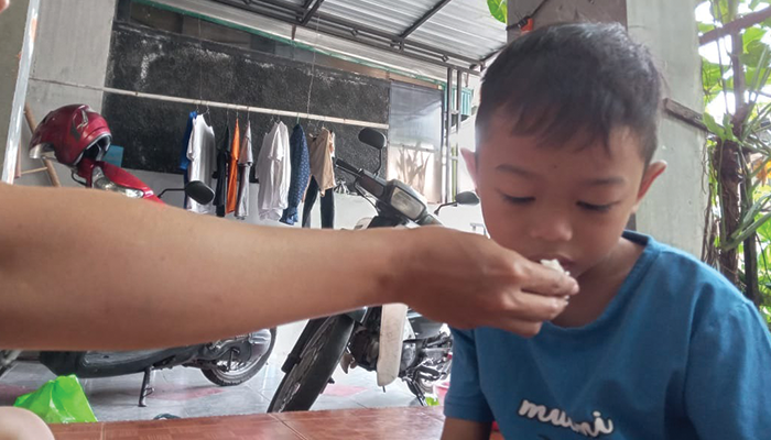 Ilustrasi orang tua yang menyuapi anak makan.