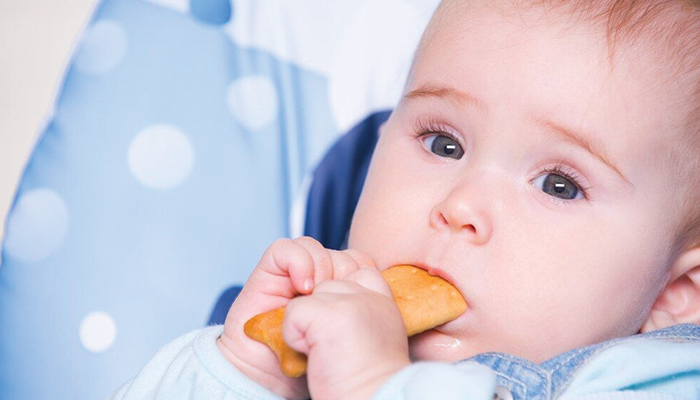 bayi memakan snack.