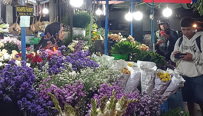 Orang yang sedang membeli bunga di pasar kembang solo.