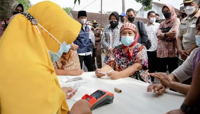 Menteri Sosial Tri Rismaharini menyaksikaan proses pencairan dana bansos kepada keluarga penerima manfaat di Desa Melis, Trenggalek, Sabtu (24/12)