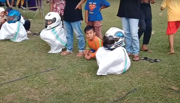 Balap karung menggunakan helm.