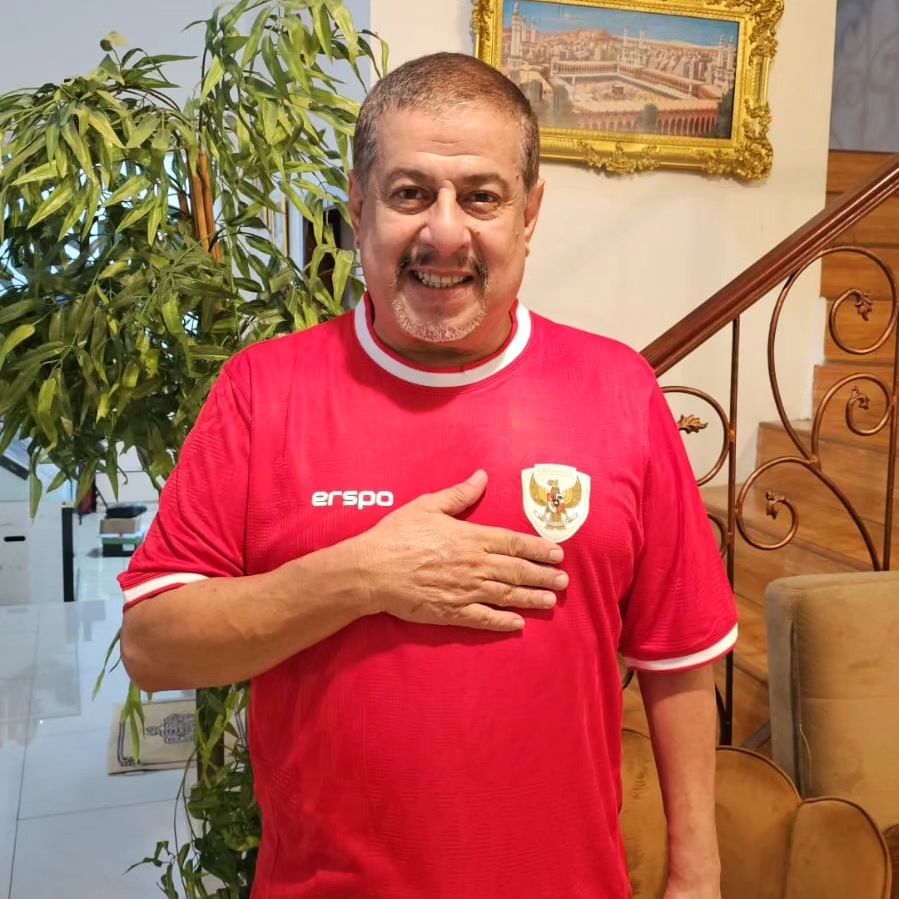 Pak Muh menggunakan jerseys Timnas Indonesia.