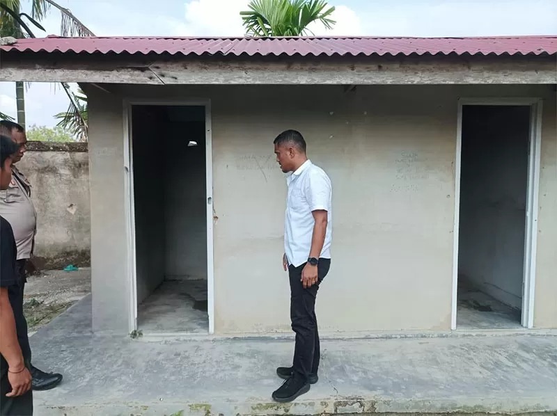 PS Kanit IV Sakreskrim Polres Siak Aipda&nbsp;Leonar Pakpahan SH berada di depan toilet rumah ibadah mengecek lokasi korban NFN (13) dirudapaksa, Selasa (1/10/2024).