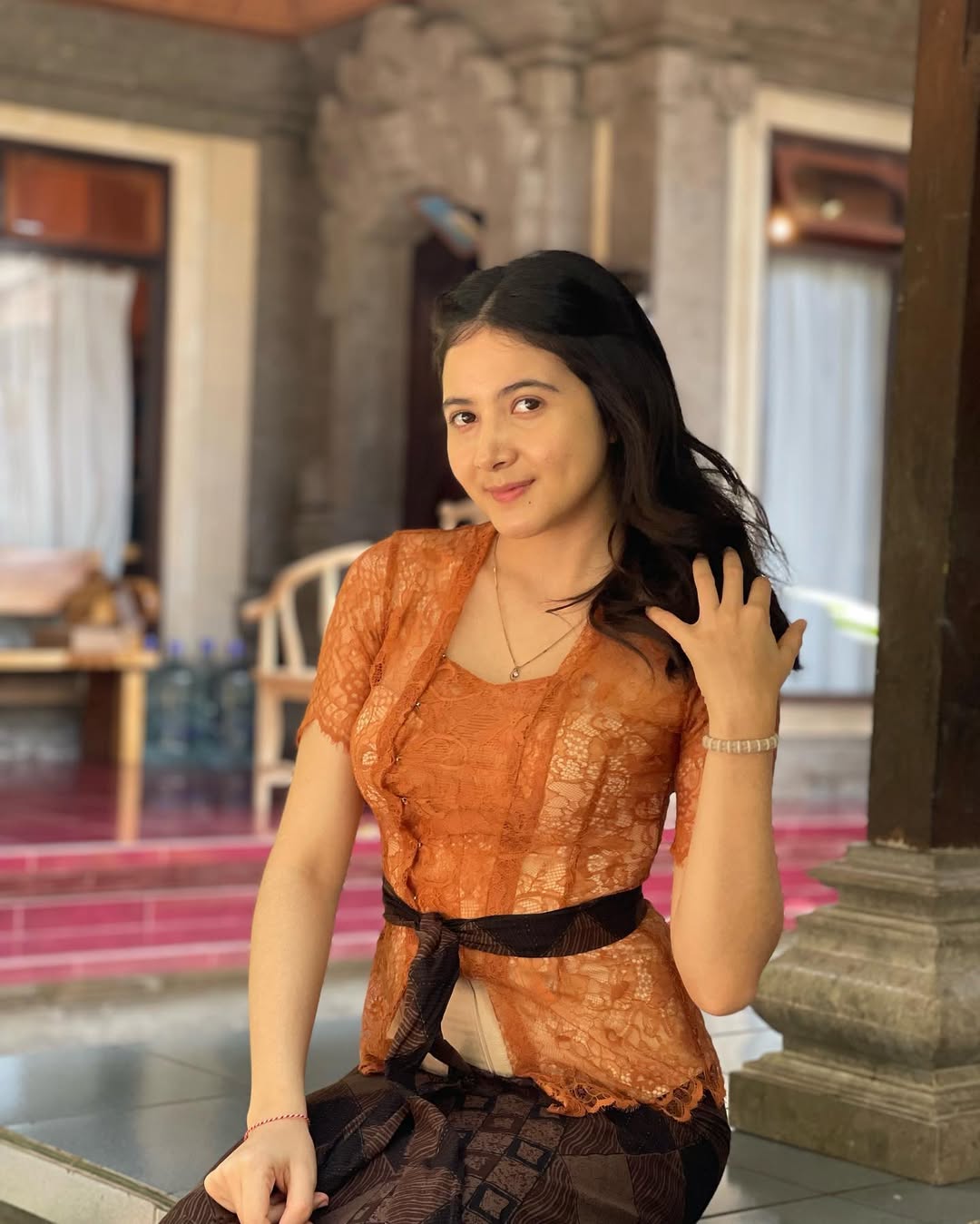 Bulan Sutena mengenakan kebaya bali cokelat keemasan.