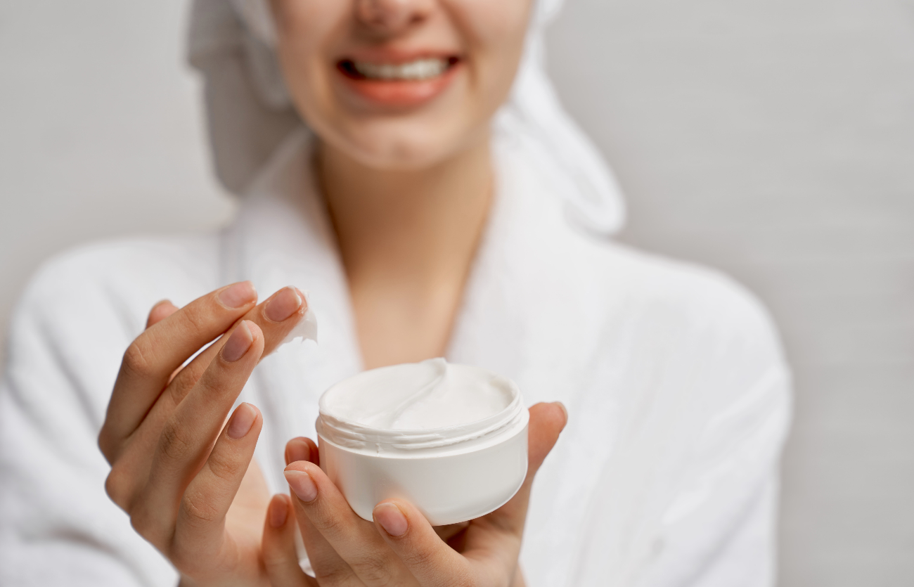 Ilustrasi wanita menggunakan moisturizer.