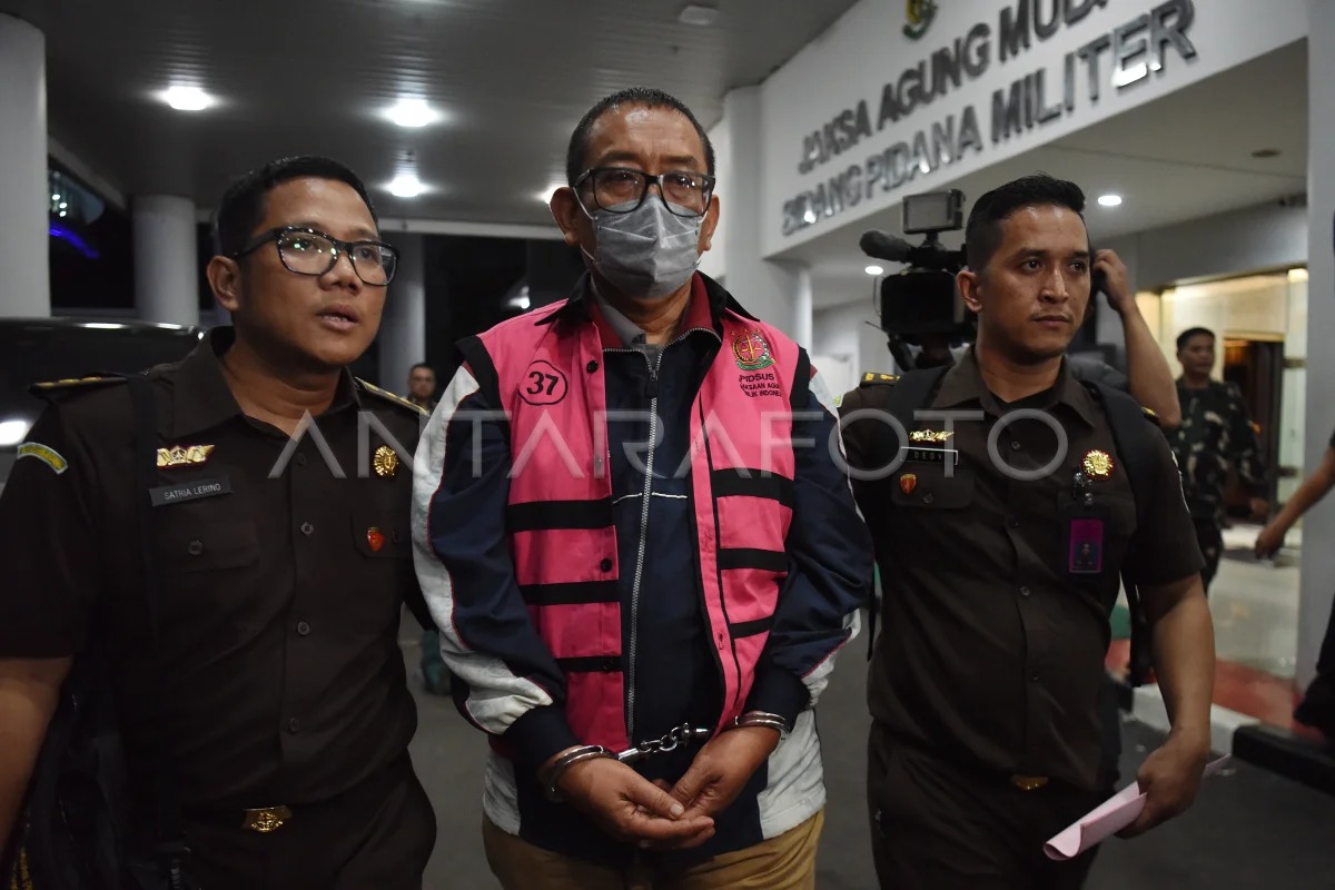 Direktur Pemberitaan JakTV Tian Bahtiar (tengah) dikawal petugas menuju mobil tahanan usai menjalani pemeriksaan di Gedung Kejaksaan Agung, Jakarta, Selasa (22/4/2025).