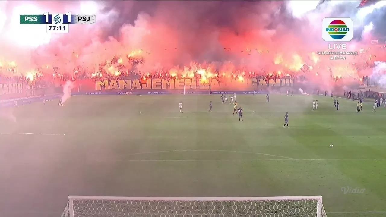 Flare menyala di stadion Maguwoharjo saat pertandingan PSS kontra Persija.