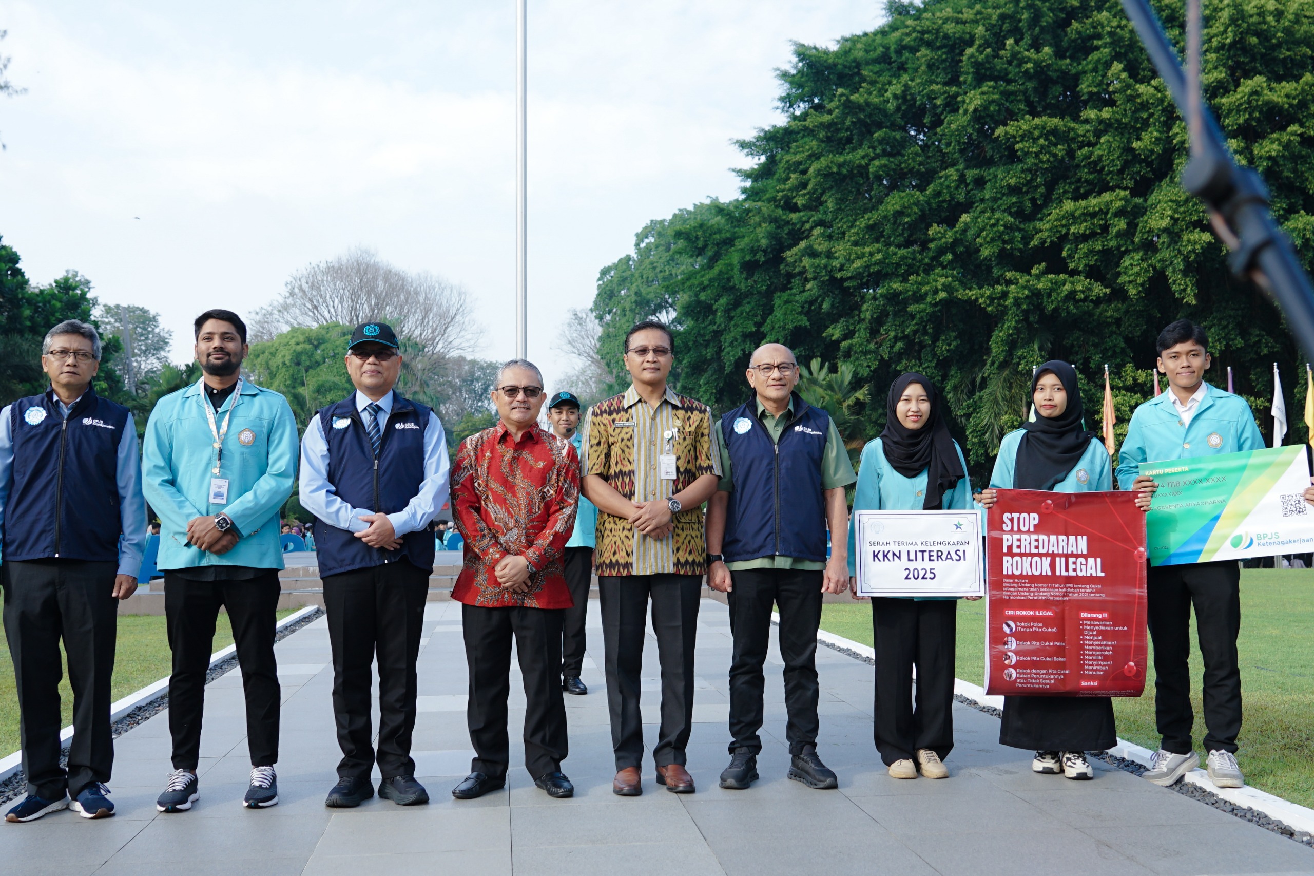 Simbolis Deputi Bidang Learning and Development BPJS Ketenagakerjaan, Suwilwan Rachmat menyerahkan kartu BPJS Ketenagakerjaan ke mahasiswa UNS peserta KKN periode Juli-Agustus 2025.