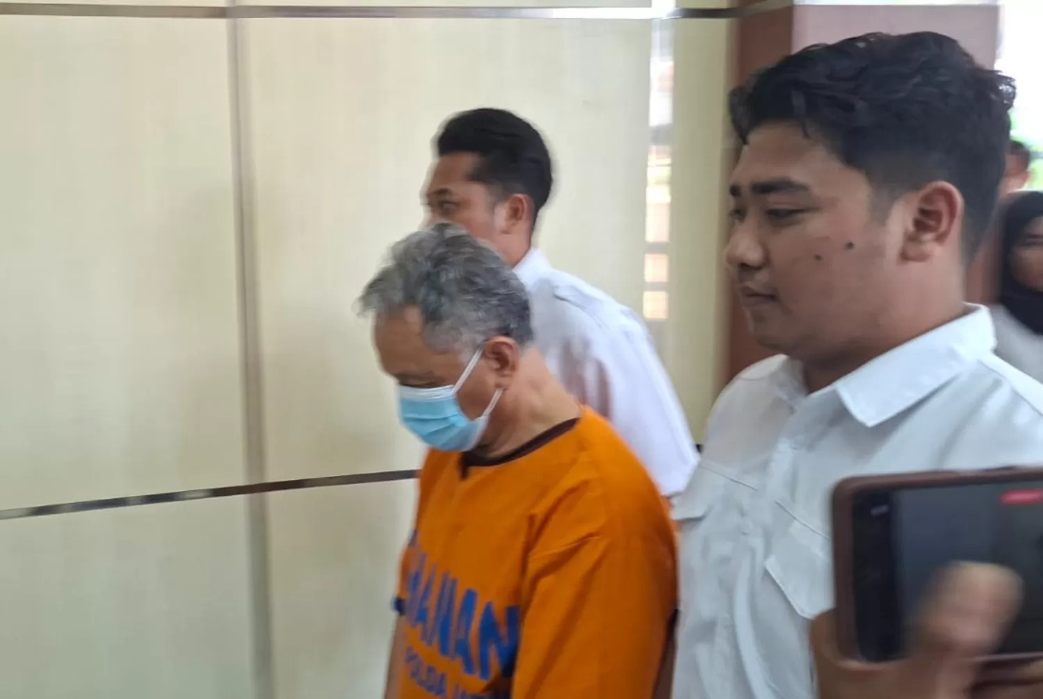 DBH, pendeta 67 tahun tersangka rudapaksa anak di bawah umur dibawa masuk kembali ke ruang tahanan usai rilis di Mapolda Jatim, rabu (16/7/2025).